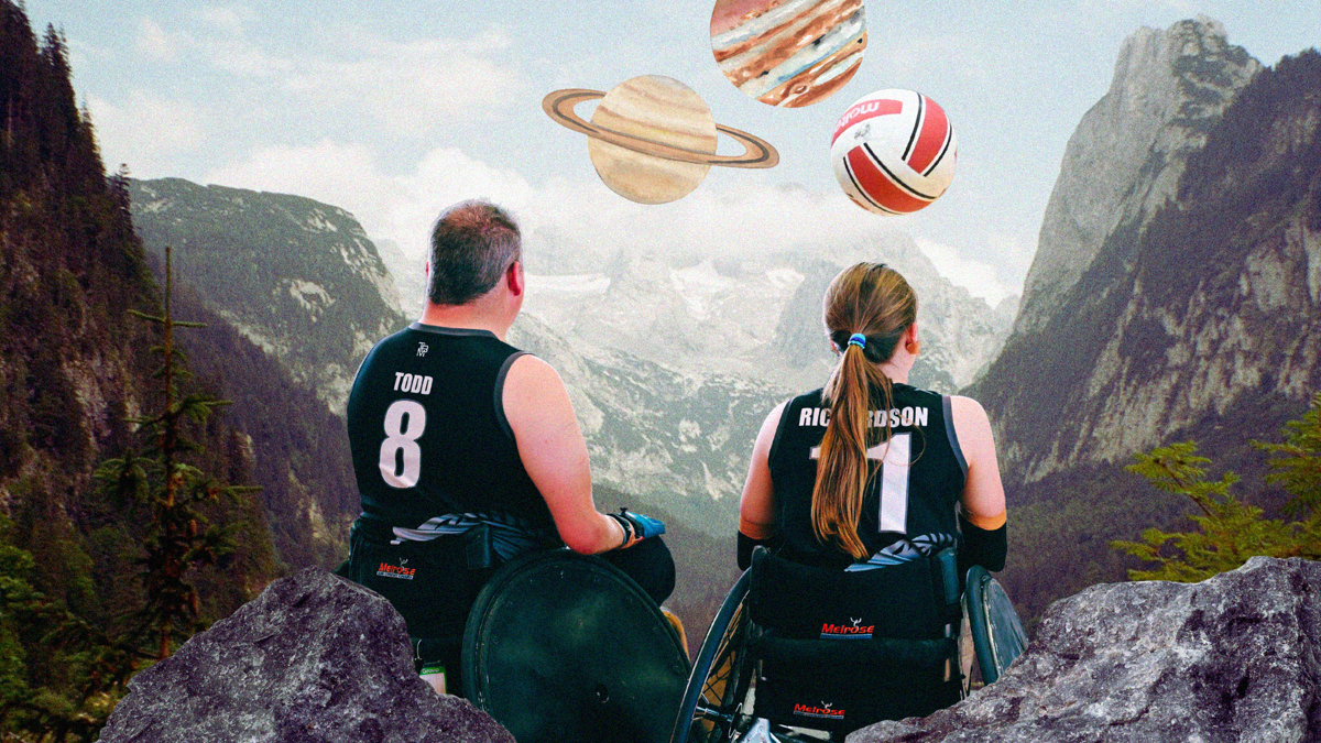 The backs of two people in wheelchairs wearing sports singlets reading "TODD 8" and "RICHARDSON 11". They are in a valley of rocky mountains looking at planets and a sports ball.