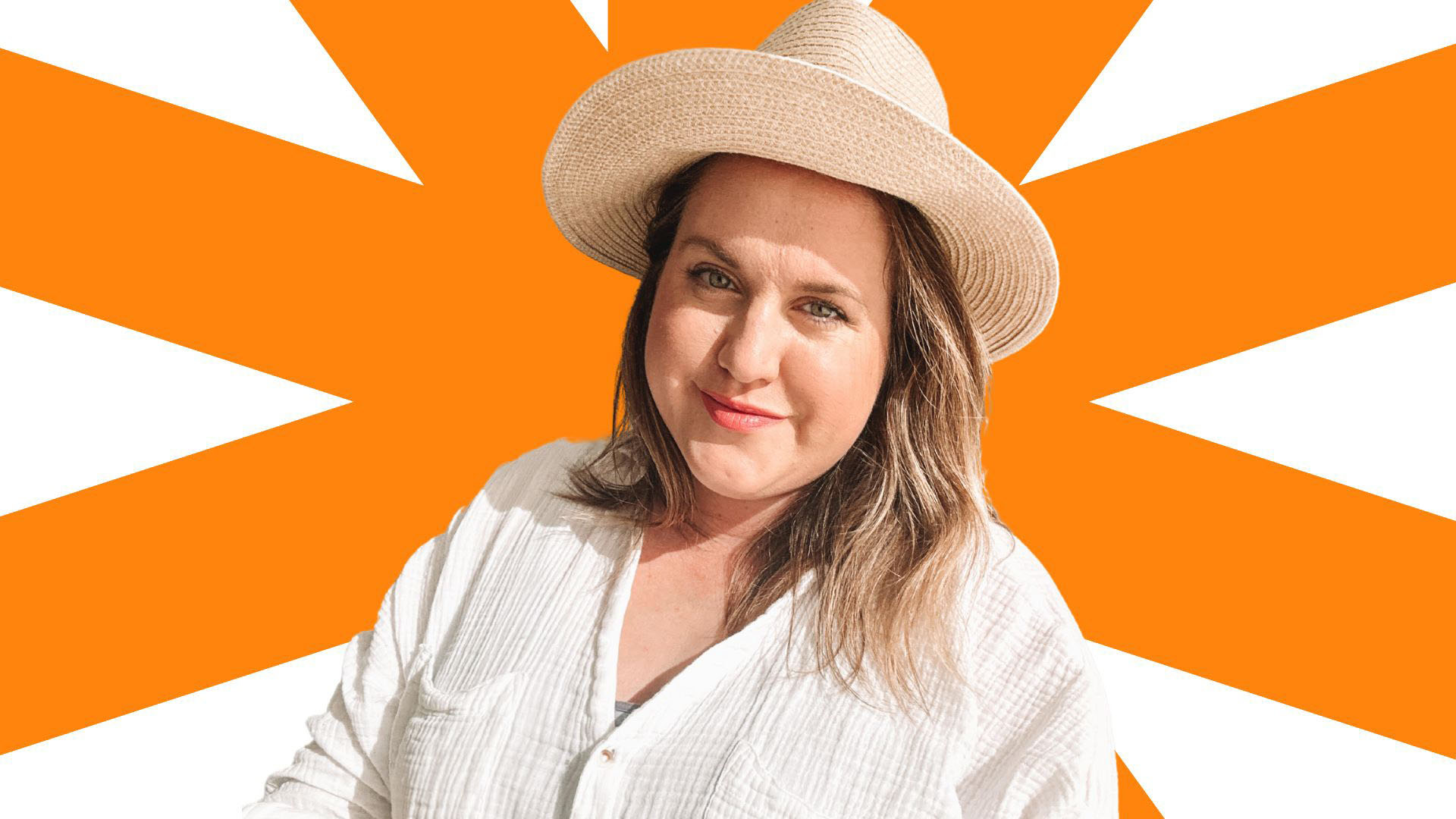 Image Description: Natalie, a woman with blonde hair, is standing looking at the camera and smiling. She is wearing a straw hat and a white button-down linen blouse, with the sleeves rolled up to her elbows. 