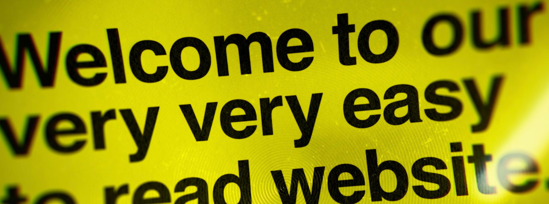 Image description: A screenshot from Blind Low Vision's website states, 'Welcome to our very, very easy to read website'. The text is black against a yellow background 