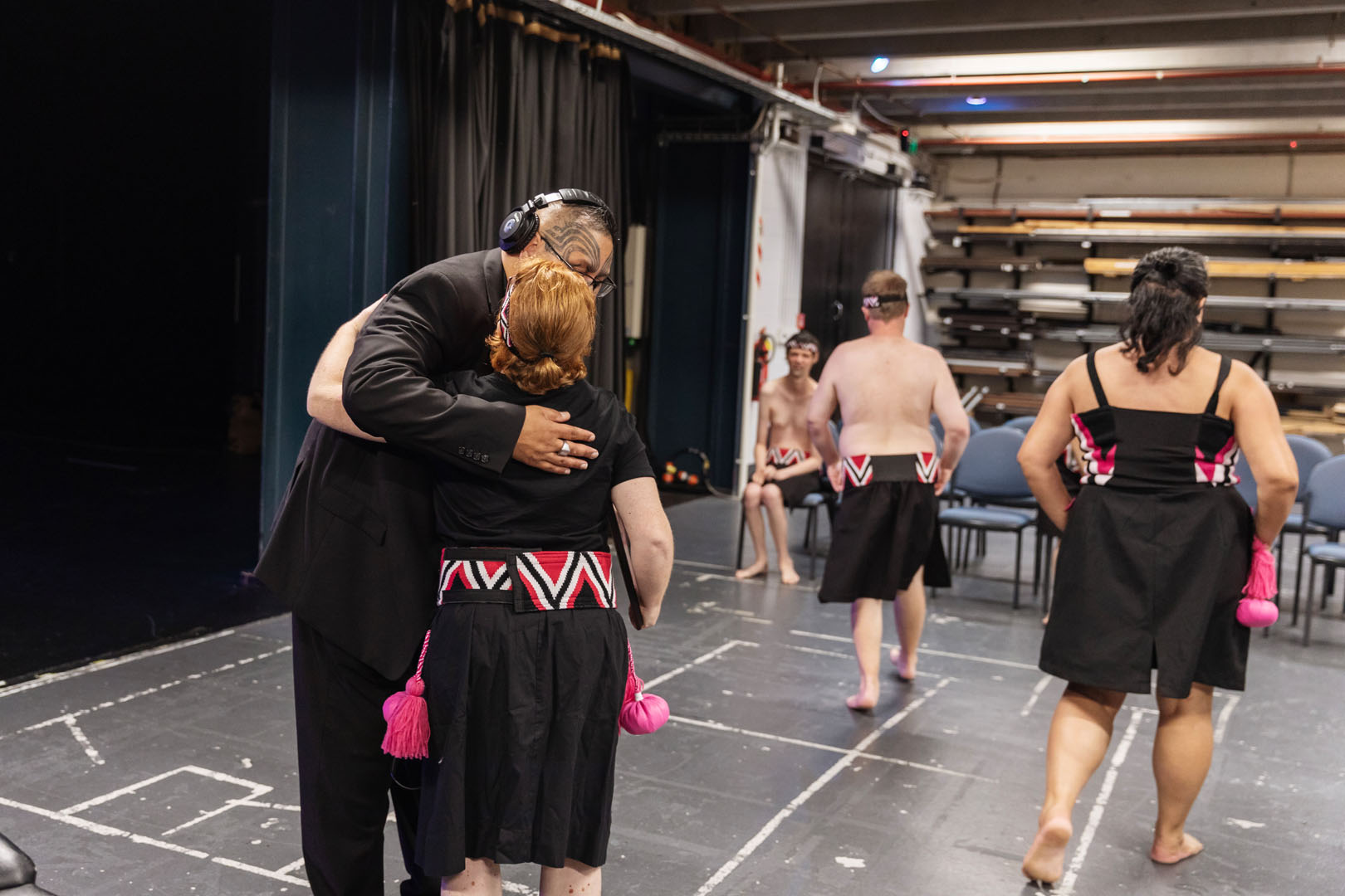 A kaihaka shares a hug backstage as everyone gets ready to go on the stage. 