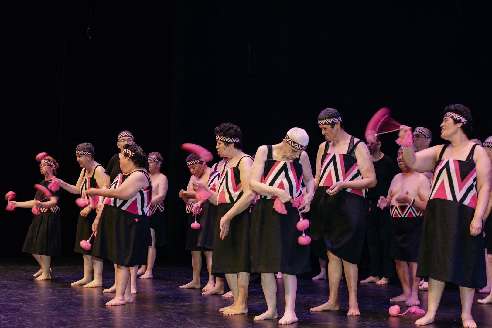 The kaihaka of Te Rōpu o te Hauāuru o Tāmaki perform on stage with pink poi.