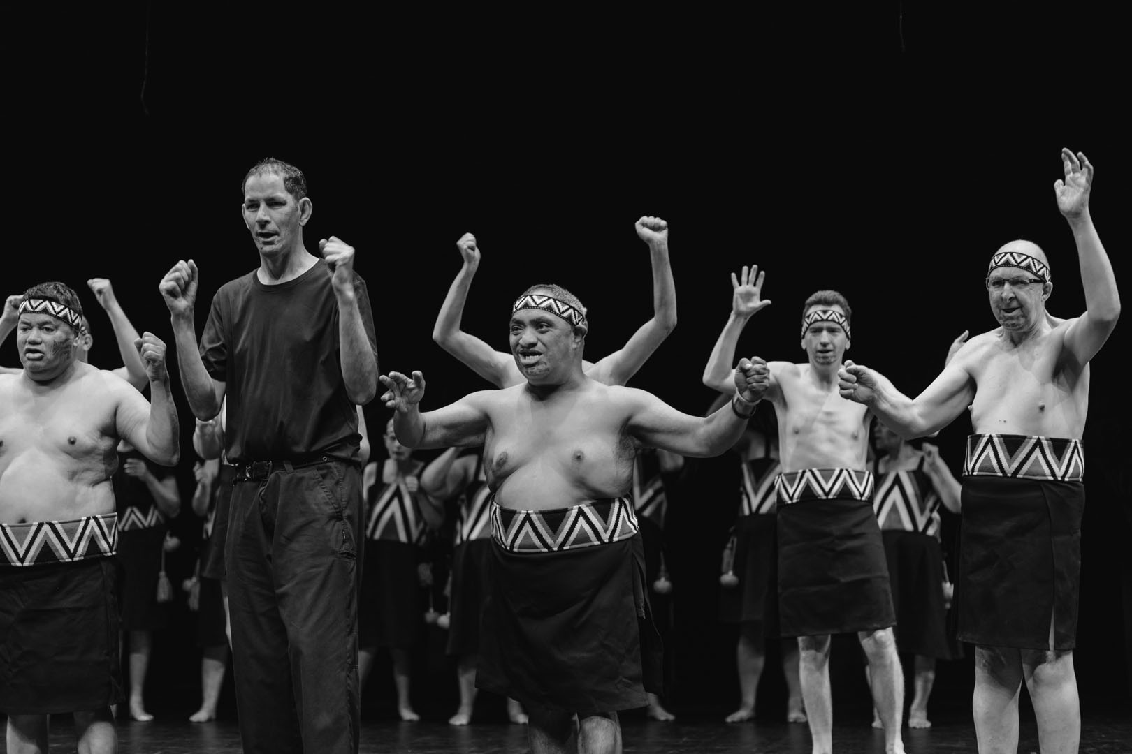 The rōpū members do a haka. The photo is black and white. 
