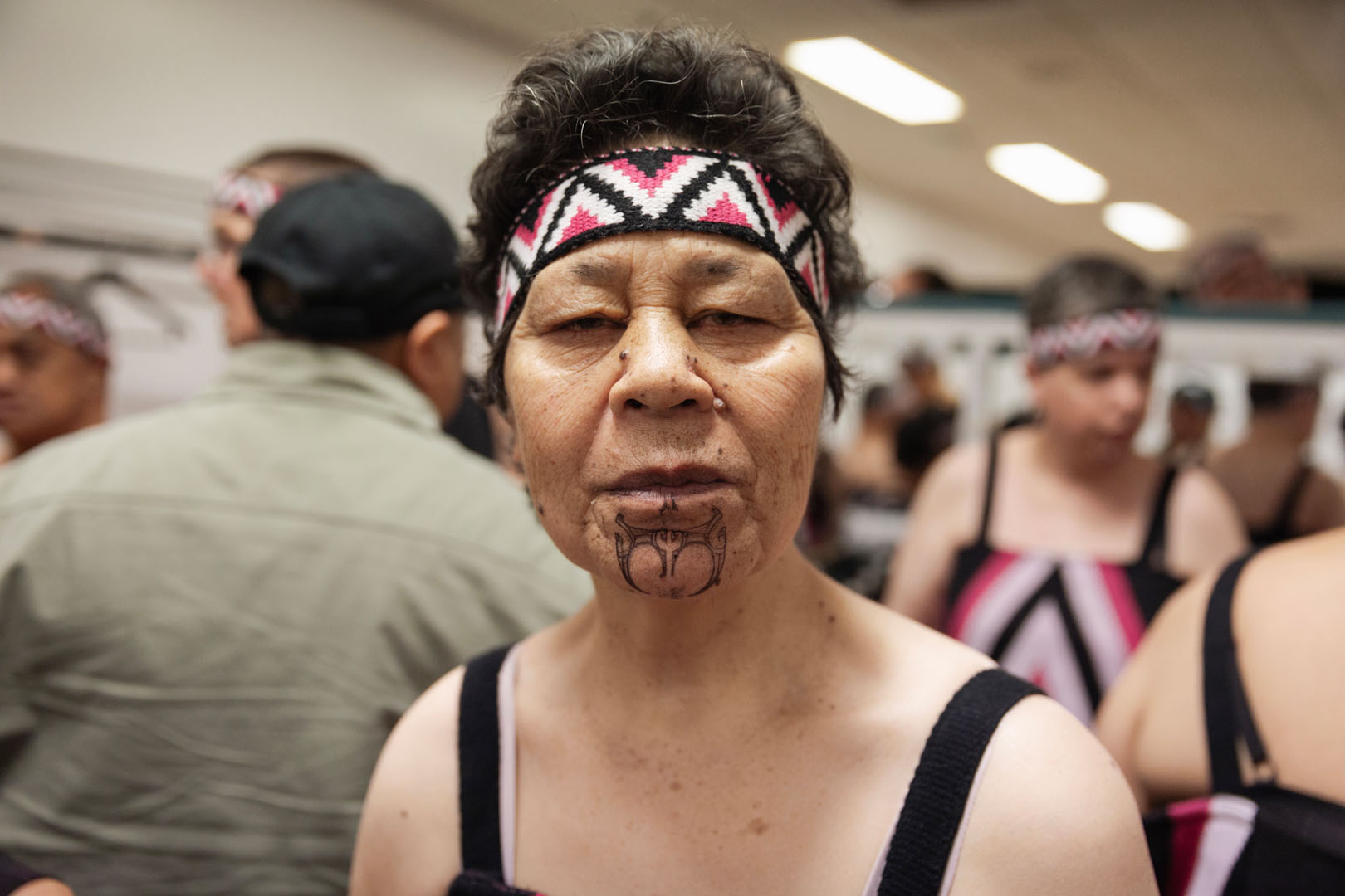 A close-up of a kaihaha with ta moko; they are looking straight at the camera with a serious expression.
