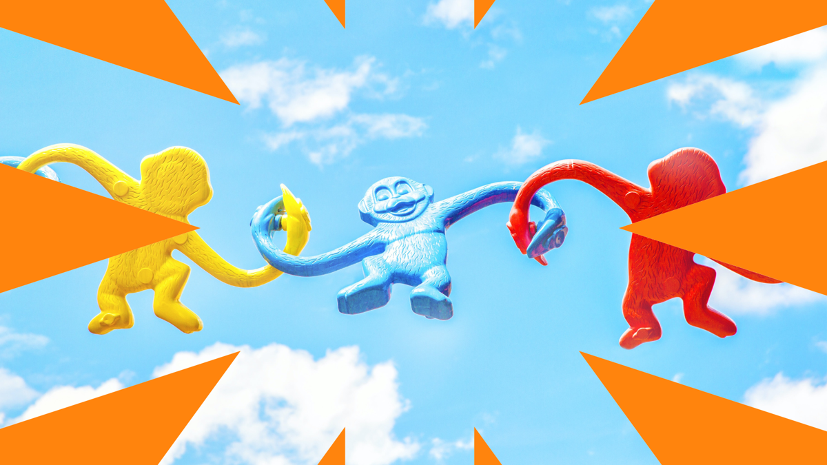 Toy monkeys loop arms in a chain against a blue sky background, and surrounded by orange star bursts  