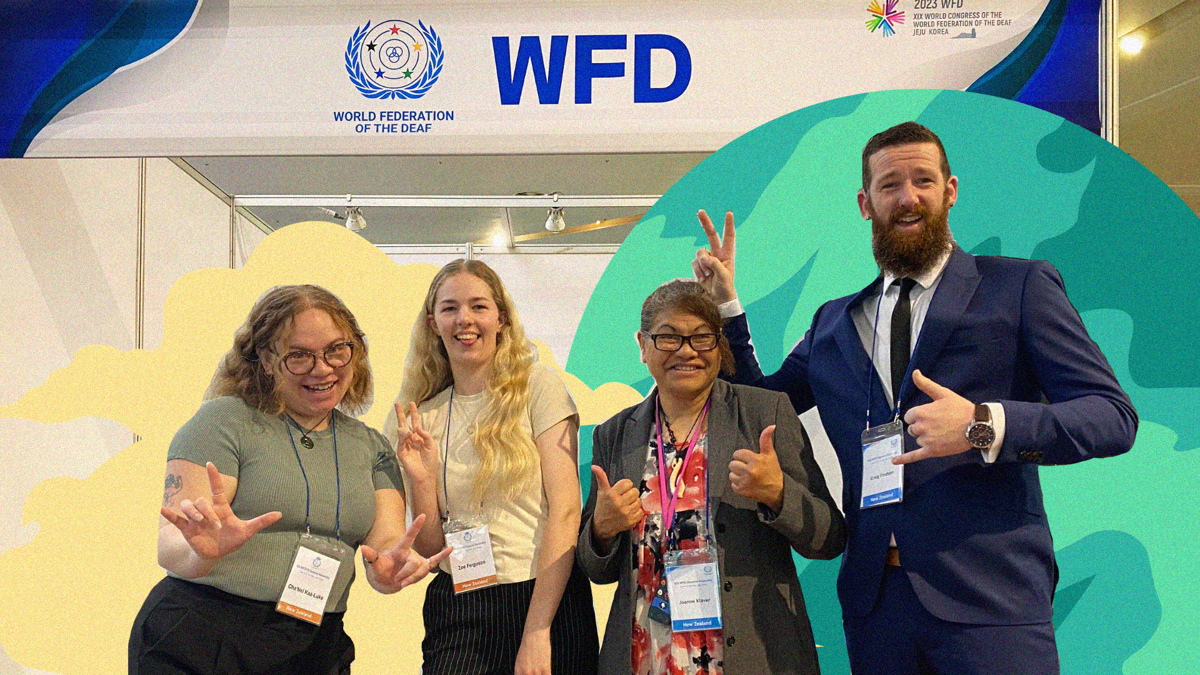 Four people hold up 'peace' signs or give thumbs up to the camera, in front of a sign that reads: World Federation of the Deaf, WFD