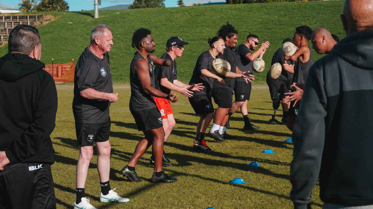 Photo of the Whaikaha Kiwis at training passing rugby balls around 