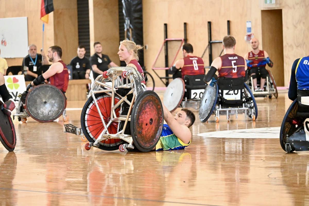 A Brazilian wheelchair rugby is tipped backwards in his wheelchair on the court.