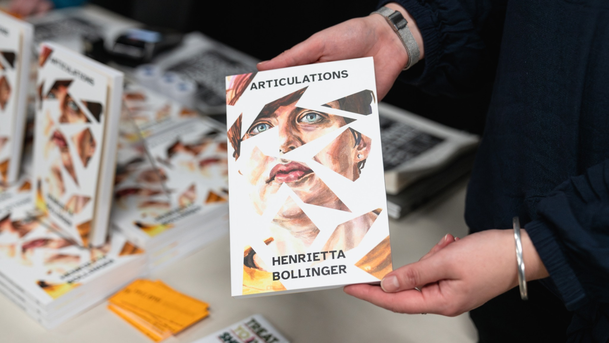 Image description: Henrietta's book cover is held by a person's two hands.