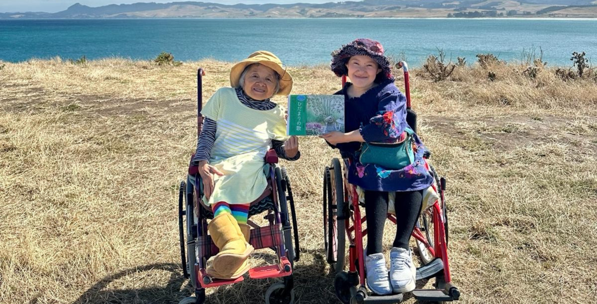 Yuho and Umi are pictured in their wheelchairs with an ocean view behind them.