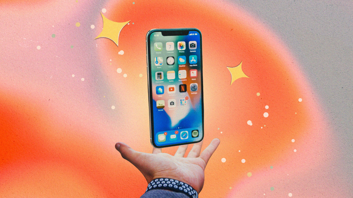 An iPhone is floating above a hand with and orange and pink glowing background with stars.