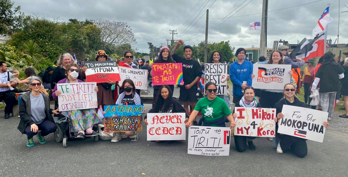 A group of people with Te Tiriti banners