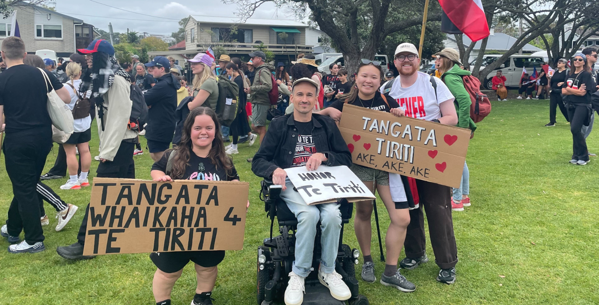 Disabled people at a protest with signs