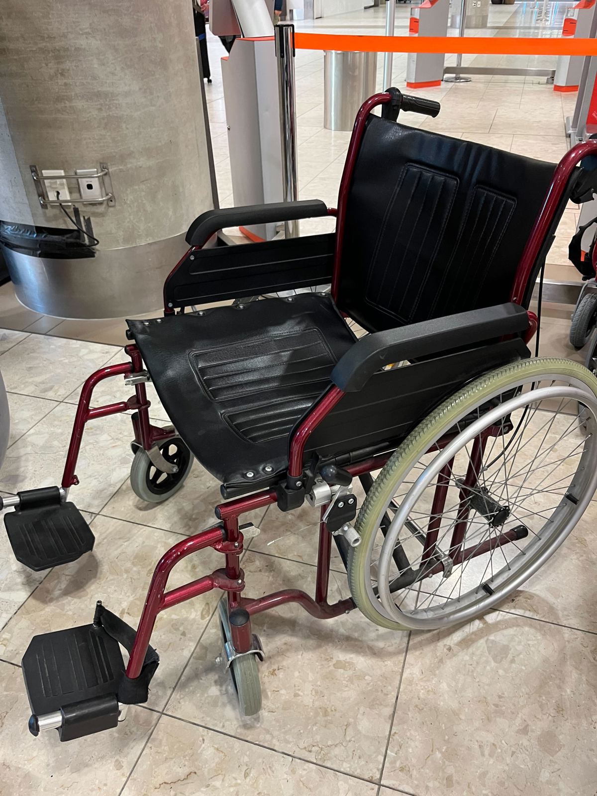 Black airport wheelchair with red frame